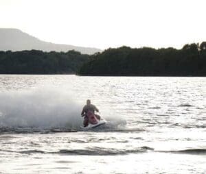 Free Things to Do in Fermanagh KILLADEAS, ENNISKILLEN, IRELAND - JULY 2018 Man riding a jetski on Lough Erne